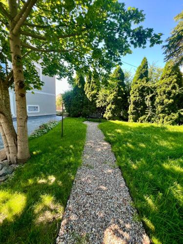 a path through a park with trees and grass at Apartament Frombork Łempicka in Frombork