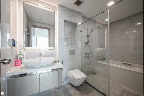 a bathroom with a sink and a toilet and a shower at The Luxe Nest Riverside - Vinhome Landmark 81 in Ho Chi Minh City