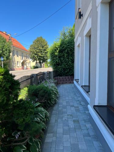 a walkway outside of a building with plants at Apartament Frombork Łempicka in Frombork