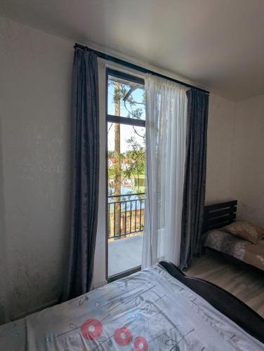 a bedroom with a bed and a large window at Palm trees in Ureki