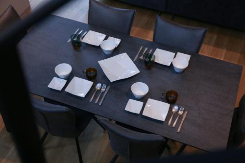 a black table with white plates and silverware on it at 62 Fuji Petel DEUX -ドゥ- in Fujikawaguchiko