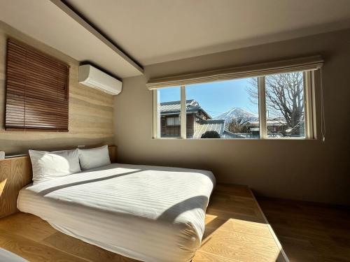 a bedroom with a large bed and a window at 62 Fuji Petel DEUX -ドゥ- in Fujikawaguchiko
