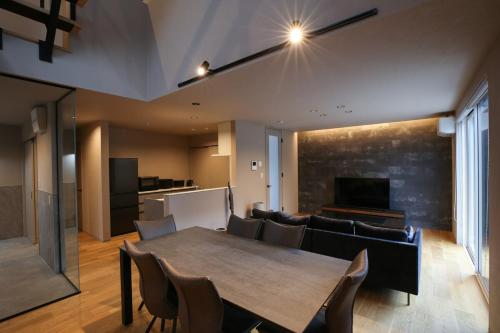 a dining room with a table and a couch at 62 Fuji Petel DEUX -ドゥ- in Fujikawaguchiko