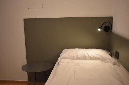 a bedroom with a bed with a table and a lamp at Residence Mirabel in Tignale