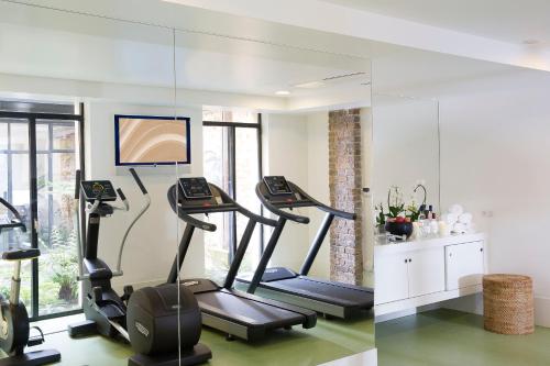 a gym with three treadmills and a mirror at Goralska Résidences Hôtel Paris Bastille in Paris