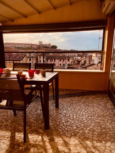a table and chairs in a room with a large window at Maison Mavino in Desenzano del Garda