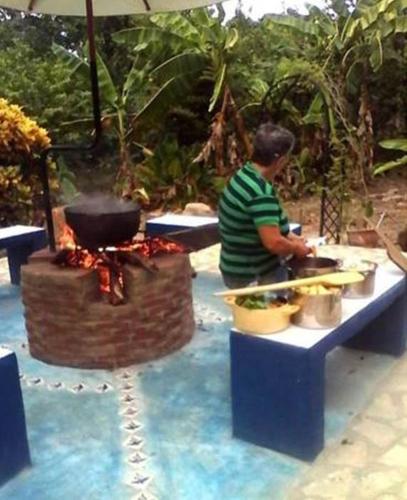 a man is preparing food on a table at Sana El Jardin Secreto in Santiago de los Caballeros