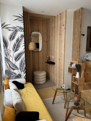 a living room with a yellow couch and a table at Eden Studio in Ajaccio