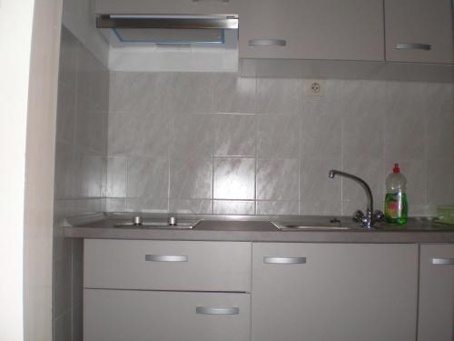 a kitchen with white cabinets and a sink at Tivoli Apartment in Ičići