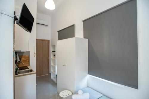 a living room with a couch and a tv at Olesia Rooms in Naousa in Naousa