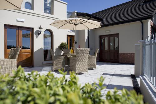 a patio with a table and chairs and an umbrella at Flagstaff Lodge in Newry