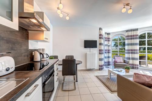eine Küche und ein Wohnzimmer mit einer Couch und einem Tisch in der Unterkunft Residenz am Balmer See - BS 37H mit Wellnessbereich in Balm