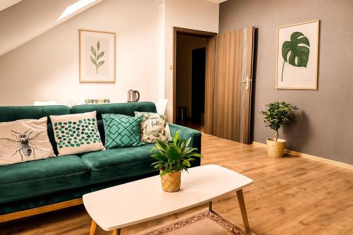 a living room with a green couch and a table at Pod Kolumnami in Pilica