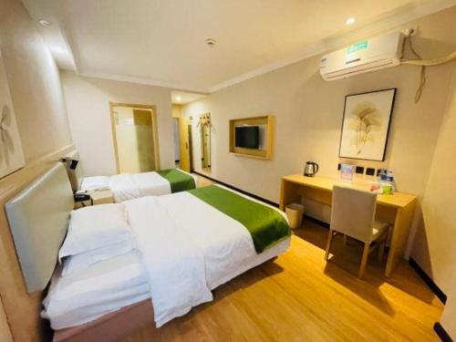 une chambre d'hôtel avec un lit et un bureau dans l'établissement GreenTree Inn Liaoning Province Huludao City Xingcheng Shoushan Express Hotel, à Xingcheng