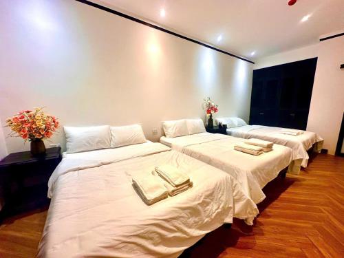 two beds in a room with white sheets and towels at Mia Garden Hotel in Dinh Ðiền Buôn Hô