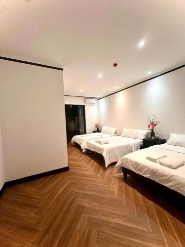 a room with two beds and a large wall at Mia Garden Hotel in Dinh Ðiền Buôn Hô