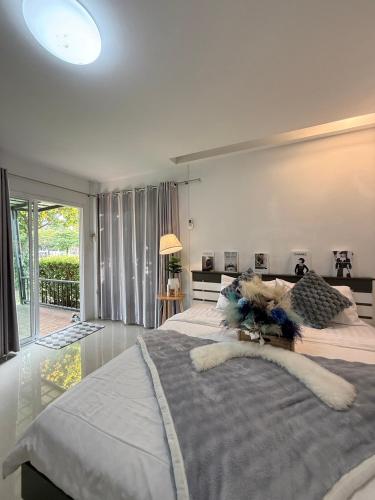 a large bedroom with a large bed and a window at Chertam Le Marjestic Hotel โรงแรม เฌอแตม ลำปาง in Ban Kat Mek