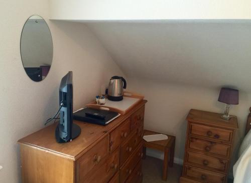 a bedroom with a desk with a computer on a dresser at Meadowcroft Guest House in Windermere