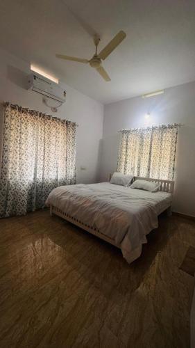 a bedroom with a bed and two large windows at Niel Valley Homestay - Poomala in Mulagunnathukāvu