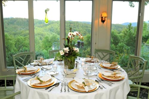 a table with plates and glasses and flowers on it at Orchard Inn in Saluda
