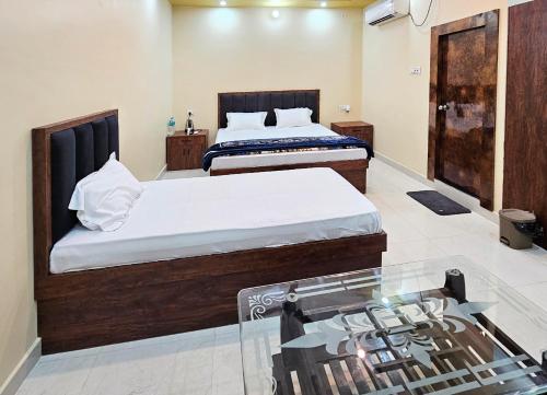 a bedroom with two beds and a glass window at Ojas Royale - Banquet and Hotel in Prayagraj