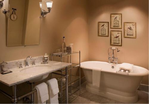 ein Badezimmer mit zwei Waschbecken, einer Badewanne und einem Spiegel in der Unterkunft Enchante Boutique Hotel in Los Altos