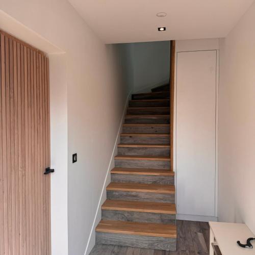 a staircase in a house with wooden floors at LEPTILOFT BAYEUX Centre in Bayeux