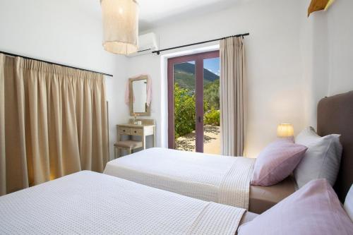 Una habitación de hotel con dos camas y una ventana. en Amapola Boutique Villas with Sea Access - Phos, en Sivota