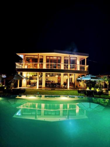 a large building with a swimming pool at night at The Clouds Resort Goa in Goa