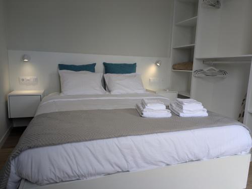 Un dormitorio con una cama grande con toallas. en Monte Gordo Accommodation, en Ribeira Brava