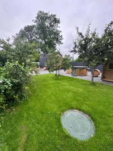 a green yard with a grate in the grass at my-tinyhouse in Neuendorf-Sachsenbande