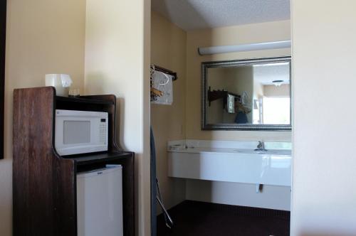 y baño con lavabo y microondas. en Carom Inn a Travelodge by Wyndham Denham Springs-Baton Rouge en Denham Springs