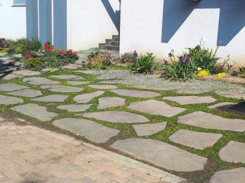 a garden with a stone walkway in front of a house at פשוט גולן in Bruchim Qela' Alon