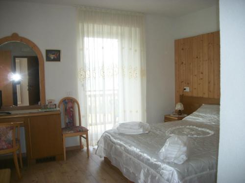 a bedroom with a bed and a sink and a mirror at Agri-park Casa Miramonte in Ronzone