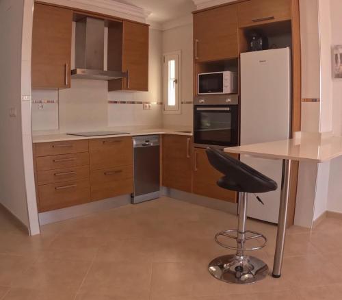 a kitchen with a table and a black chair in it at Acogedor y excelente ubicación in Puerto de Sagunto