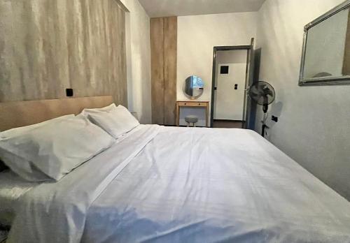 a white bed in a room with a mirror at Valla Studio in Rhodes Town