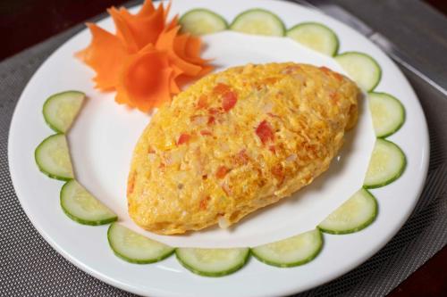 um prato de comida com omelete e pepinos em Hanoi Phoenix Premium Hotel em Hanói