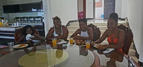 a group of women sitting at a table eating food at Amanda Villa - Best Value Mountain top Inn in Au Cap