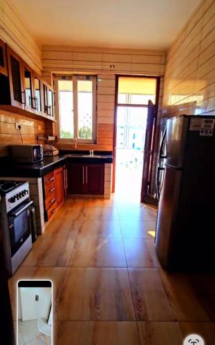 a large kitchen with wooden floors and a refrigerator at Skylight Tudor Appartments in Mombasa