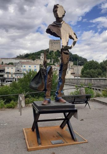 a statue of a man standing on a bench at La Bastide Millassole in Aouste-sur-Sye