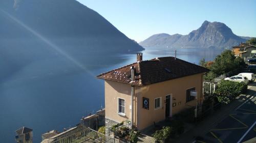 a house with a view of a lake and a mountain at Ristorante le bucce di Gandria in Gandria
