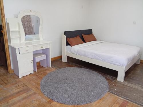 MweigaLe Tai Village Homestay的一间卧室配有床、梳妆台和镜子