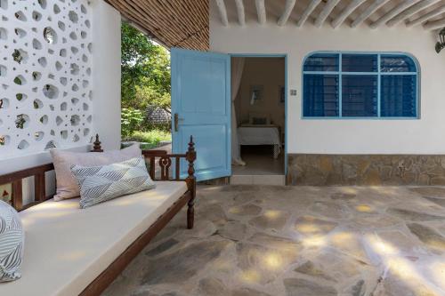 a living room with a couch and a window at Allamanda Boutique Hostel in Galu