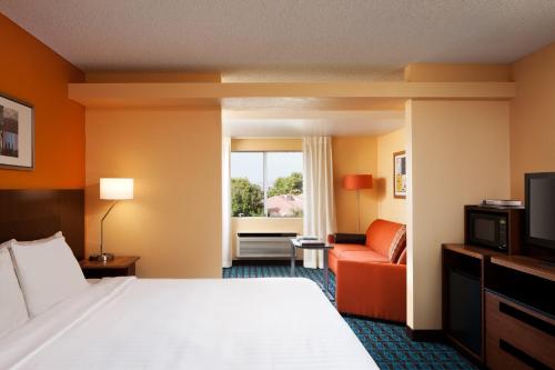 a hotel room with a bed and a couch at Country Inn & Suites by Radisson, Phoenix Airport, AZ in Phoenix