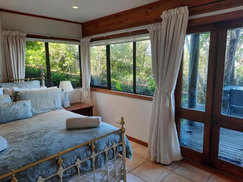 a bedroom with a bed and large windows at Titore Lodge in Russell