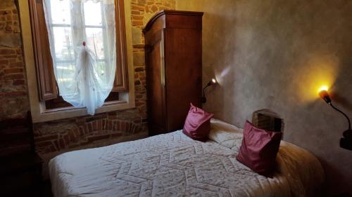 a bedroom with a bed with red pillows and a window at Tangohotel in Lucca