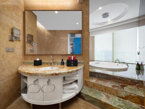 a bathroom with a large sink and a tub at Days Hotel & Suites China Town---Five minutes to reach Changsha Station, the metro Line 2 & Line 6 are nearby,free gym & laundromat,Chinese and Western buffet breakfast is offered on the 31st floor in Changsha