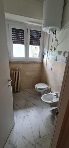 a bathroom with a toilet and a sink at Centro Lecco Piazza Manzoni in Lecco