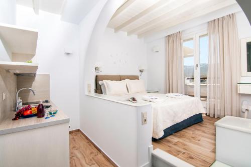 カタポラにあるSkopelitis Villageの白いベッドルーム(ベッド1台、窓付)