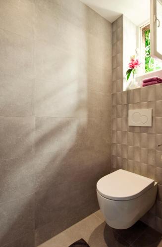 a bathroom with a toilet and a flower in a window at B&B Antonius beej de Maas in Venlo